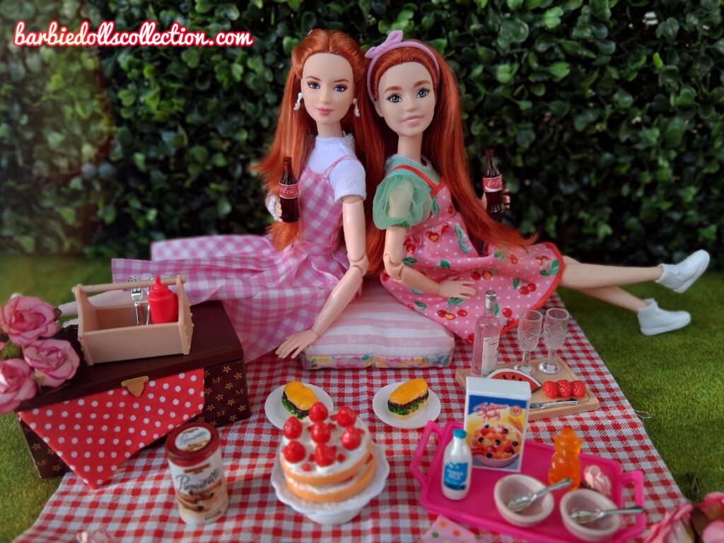 Wide view of a Barbiecore summer picnic diorama with redhead Barbie dolls.