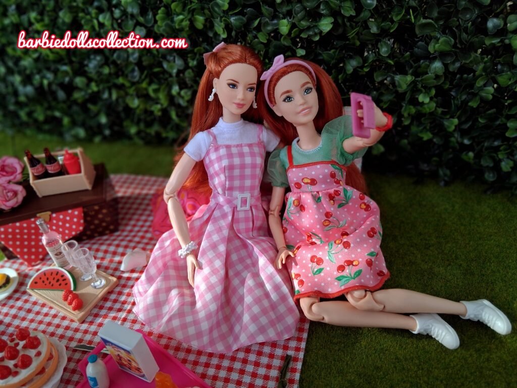 Close-up selfie of two redhead Barbie sisters during a summer picnic.