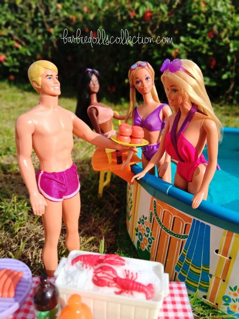 Ken offering a plate of burgers to Malibu Barbie by the pool during a summer Barbie pool party diorama scene.